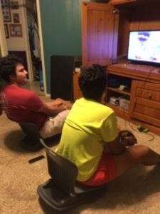 Rosario (age 17) and his brother sitting on floor rockers chillin and playing video games.