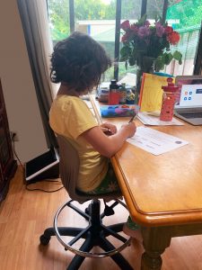 Child with proper spine alignment in chair at kitchen table